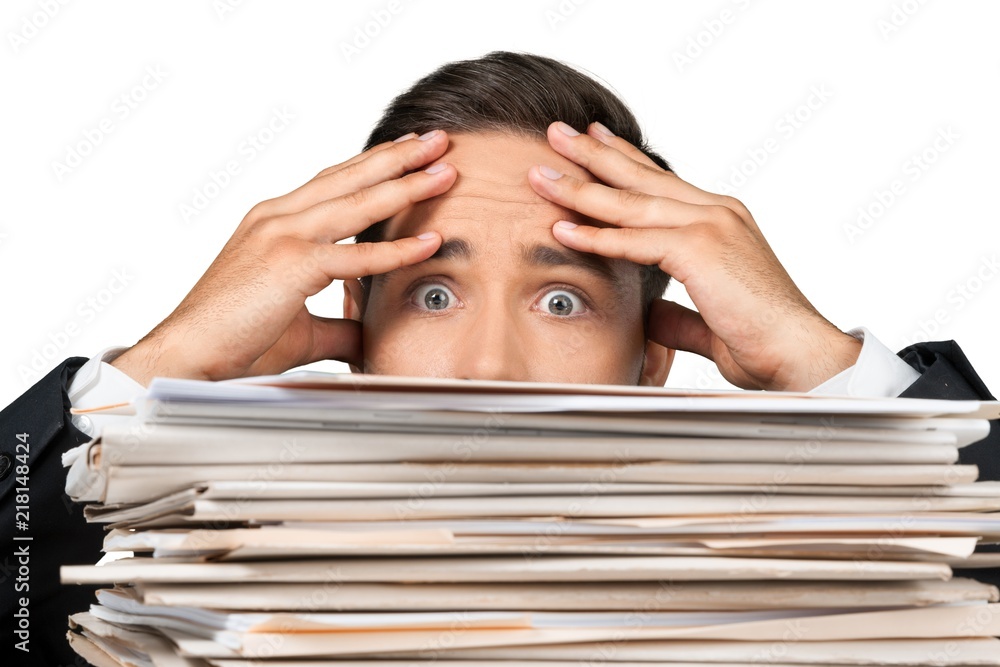 Closeup of a Worried Employee Behind Stack of Folders Closeup of a Worried Employee Behind Stack of Folders