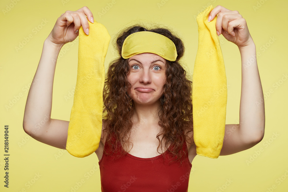 Cute European female passenger opens amenity kits on long-haul international flight with bugged blue eyes and surprised face expression. Attractive woman opens business class essential travel kit. Cute European female passenger opens amenity kits on long-haul international flight with bugged blue eyes and surprised face expression. Attractive woman opens business class essential travel kit.