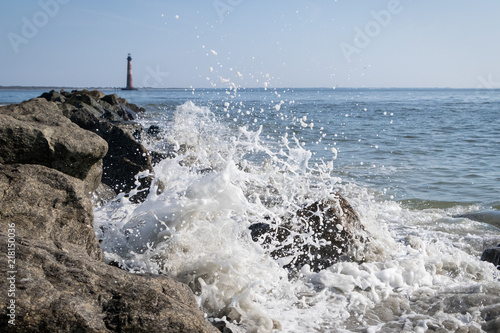 Splash on rocks with Morris Island lighthouse