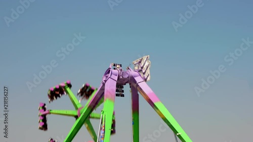 A swinging, spinning thrill ride at the carnival area of a county fair, tight shot looking up. photo