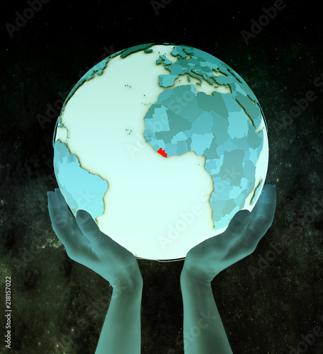 Liberia on blue globe in hands