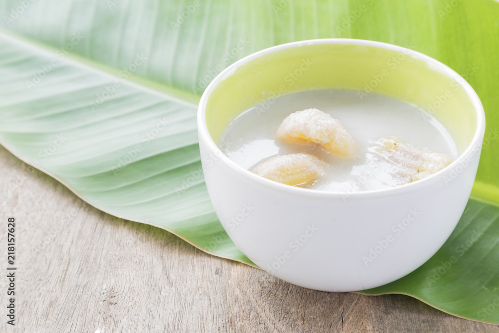 Banana in coconut milk in a white bowl on a banana leaf. Banana in coconut milk in a white bowl on a banana leaf.