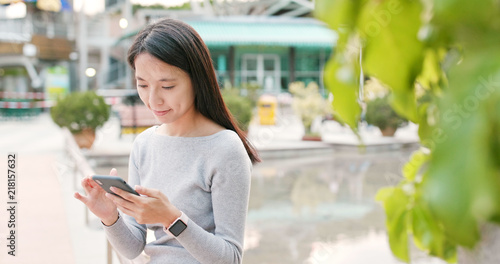 Free Download Woman use of smart phone to check for the mobile app at outdoor - GFXLoad