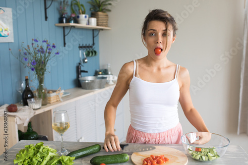 A woman preparing a salad and having fun.