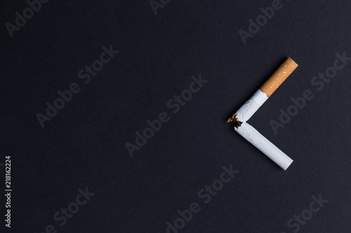 Broken cigarette on black background close-up