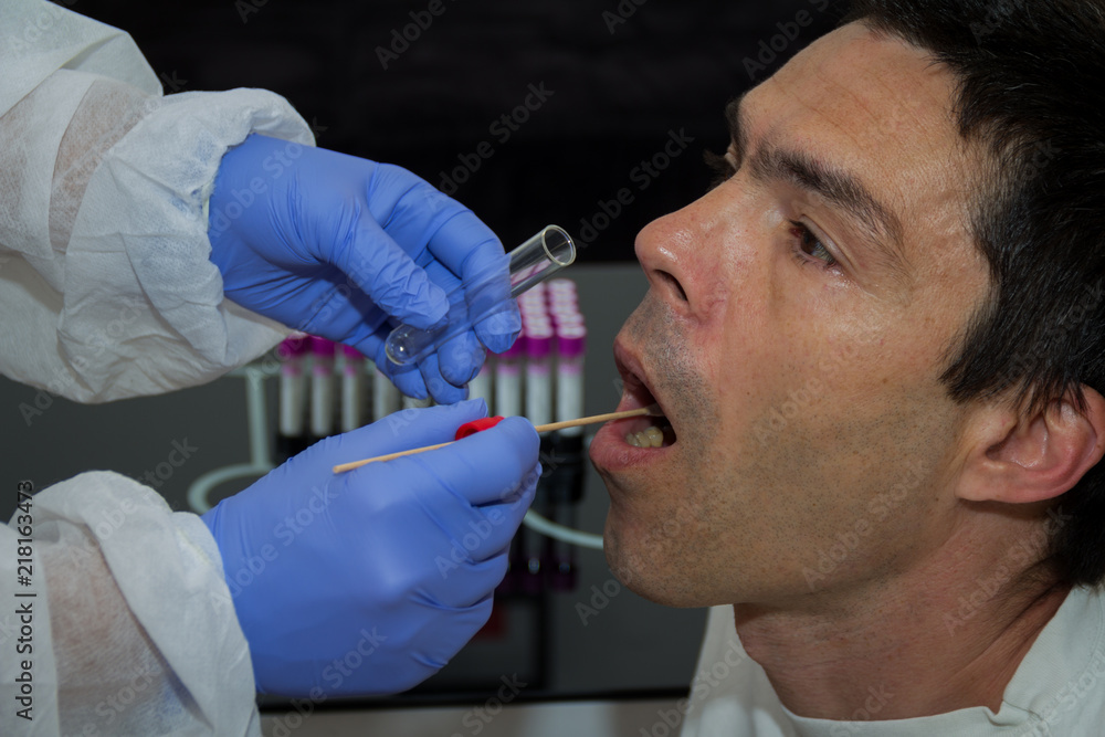 Taking a DNA sample. DNA swab of saliva taken from senior man Taking a DNA sample. DNA swab of saliva taken from senior man