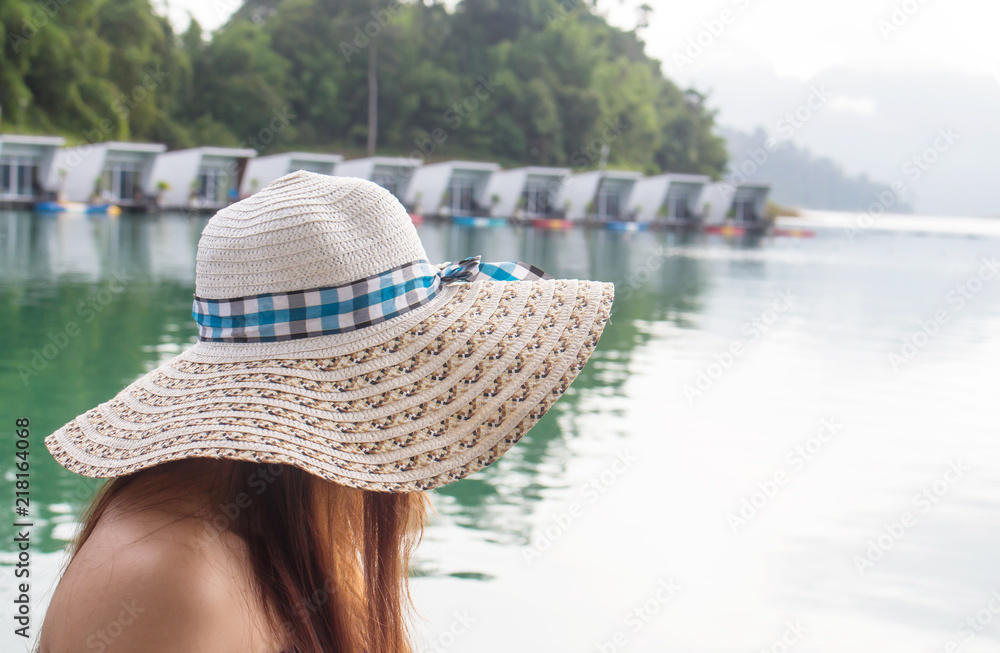 Summer holidays, travel concept .woman with straw hat in her summer holidays at the lake.