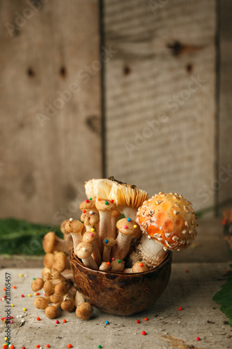 Woods, fairy tales & mysterious creature concept - poisonus mushrooms in the cup with confectionary decor on wooden table, magic, fantastic food
