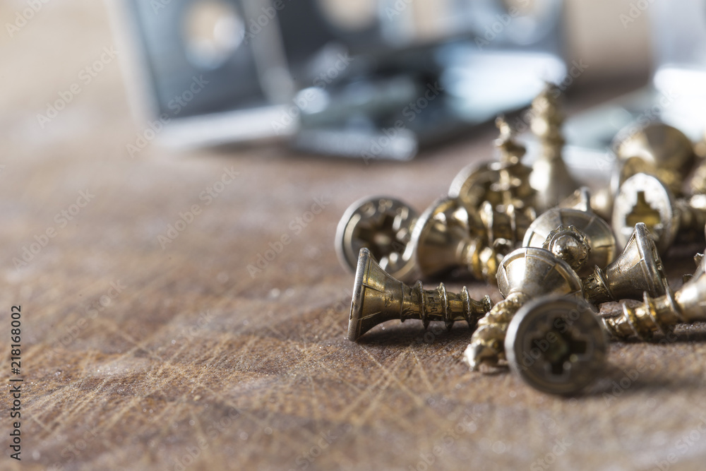 Many small screws on a wooden board Many small screws on a wooden board
