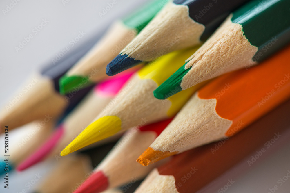 Pile of sharp coloured drawing pencils on table. Rainbow colors red, yellow, blue, green, purple. Concept of art, crafts and kids having fun Pile of sharp coloured drawing pencils on table. Rainbow colors red, yellow, blue, green, purple. Concept of art, crafts and kids having fun