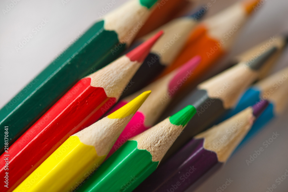 Pile of sharp coloured drawing pencils on table. Rainbow colors red, yellow, blue, green, purple. Concept of art, crafts and kids having fun Pile of sharp coloured drawing pencils on table. Rainbow colors red, yellow, blue, green, purple. Concept of art, crafts and kids having fun