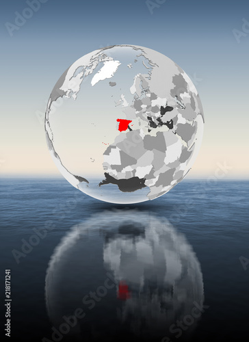 Spain on translucent globe above water