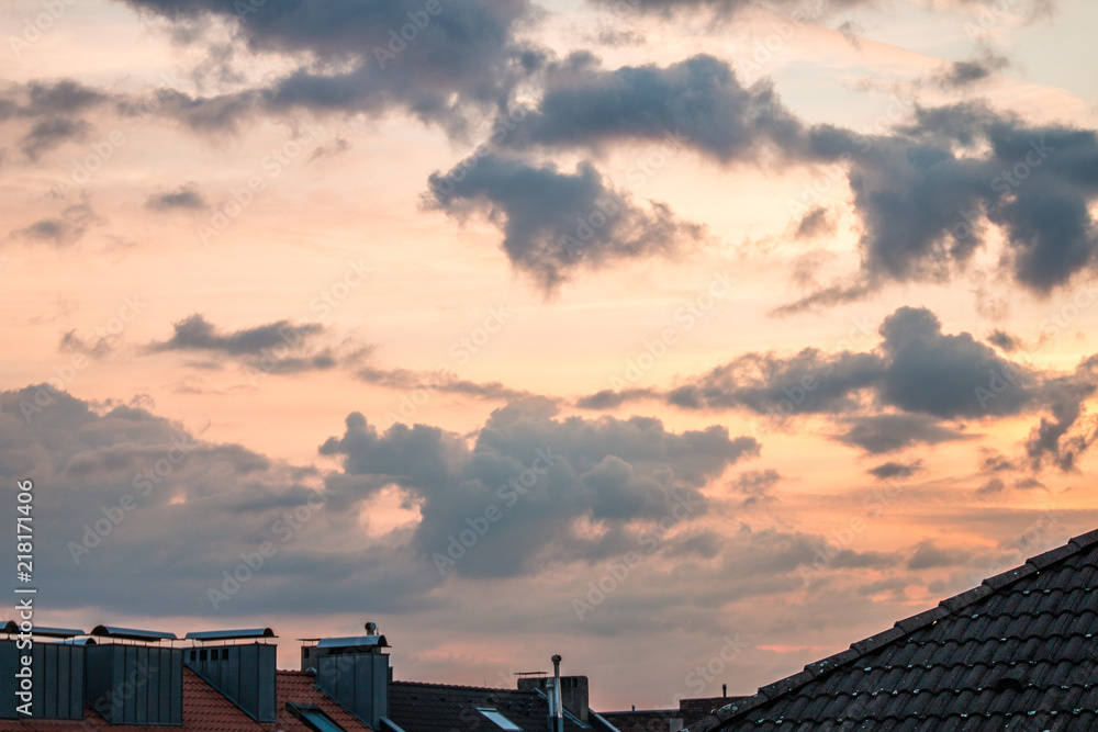 Obraz premium Roofs with chimneys and dramatic sky