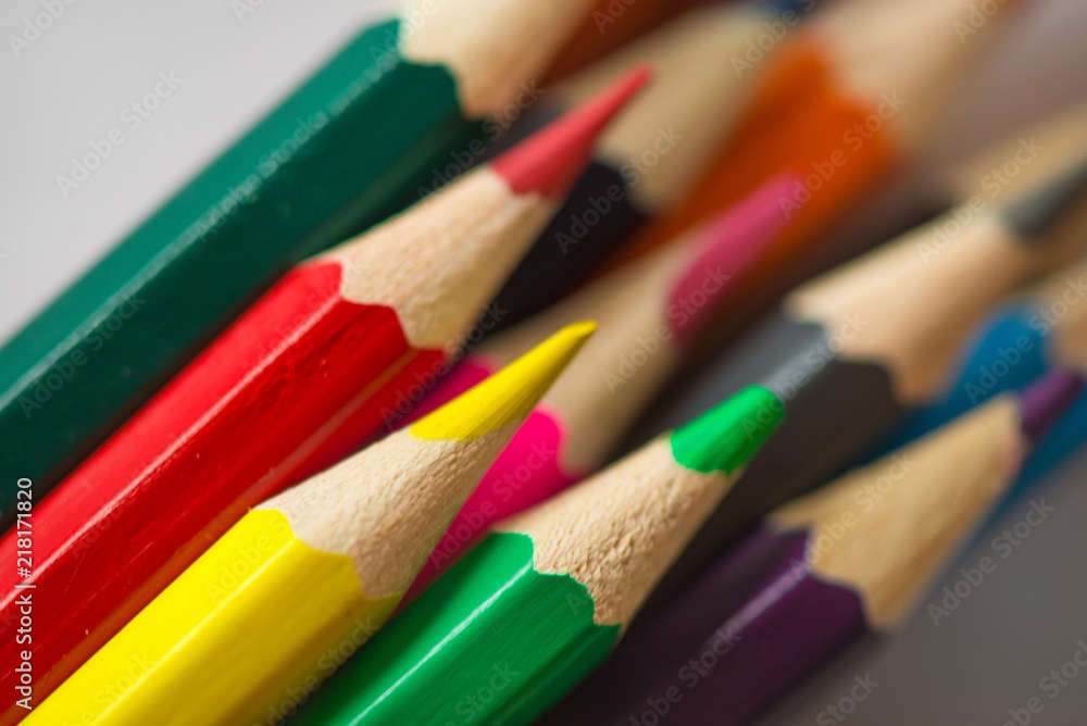Pile of sharp coloured drawing pencils on table. Rainbow colors red, yellow, blue, green, purple. Concept of art, crafts and kids having fun Pile of sharp coloured drawing pencils on table. Rainbow colors red, yellow, blue, green, purple. Concept of art, crafts and kids having fun