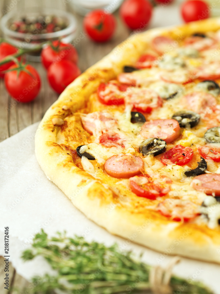 Part of homemade lagge pizza with parmesan, oregano, olives and mozzarella, sausage and tomato sauce, side view Part of homemade lagge pizza with parmesan, oregano, olives and mozzarella, sausage and tomato sauce, side view