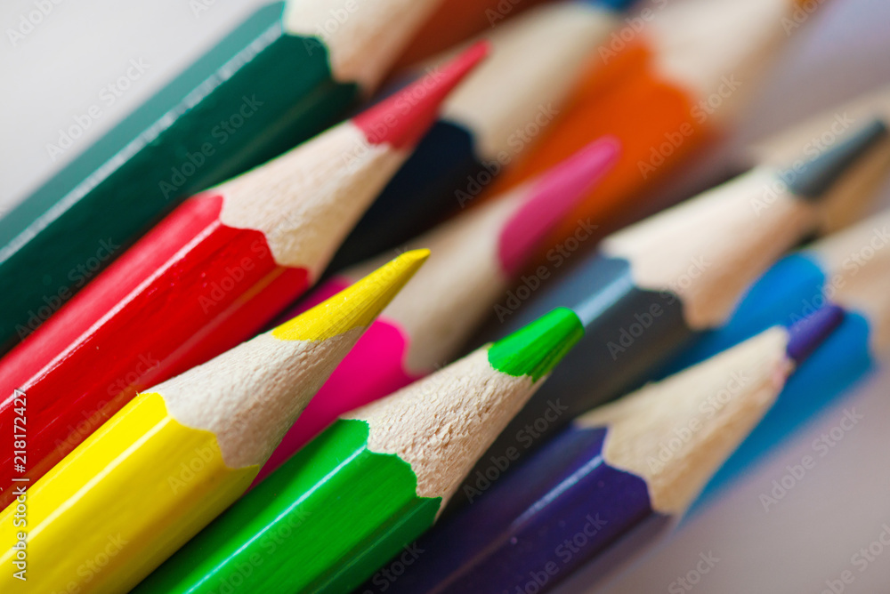 Pile of sharp coloured drawing pencils on table. Rainbow colors red, yellow, blue, green, purple. Concept of art, crafts and kids having fun Pile of sharp coloured drawing pencils on table. Rainbow colors red, yellow, blue, green, purple. Concept of art, crafts and kids having fun