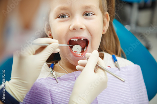 Cute child sits at dentist chair with smile