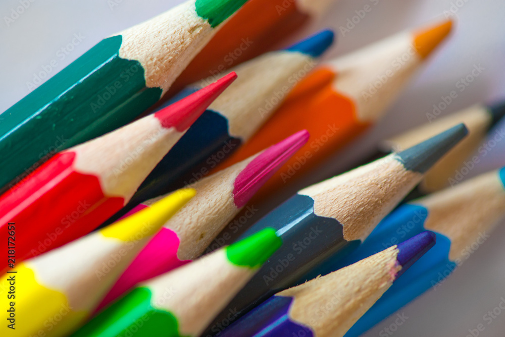 Pile of sharp coloured drawing pencils on table. Rainbow colors red, yellow, blue, green, purple. Concept of art, crafts and kids having fun Pile of sharp coloured drawing pencils on table. Rainbow colors red, yellow, blue, green, purple. Concept of art, crafts and kids having fun