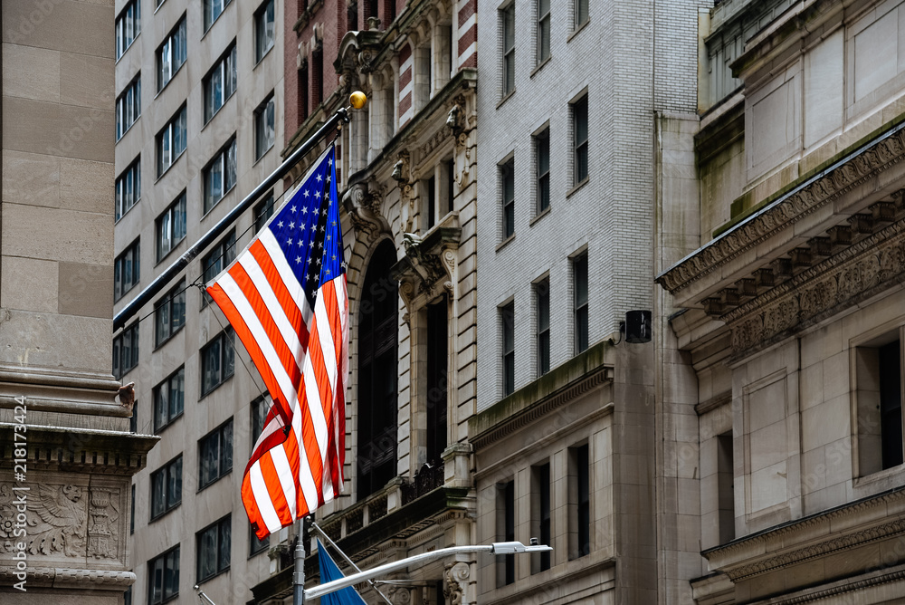 American flag waving against buildings in Wall Street