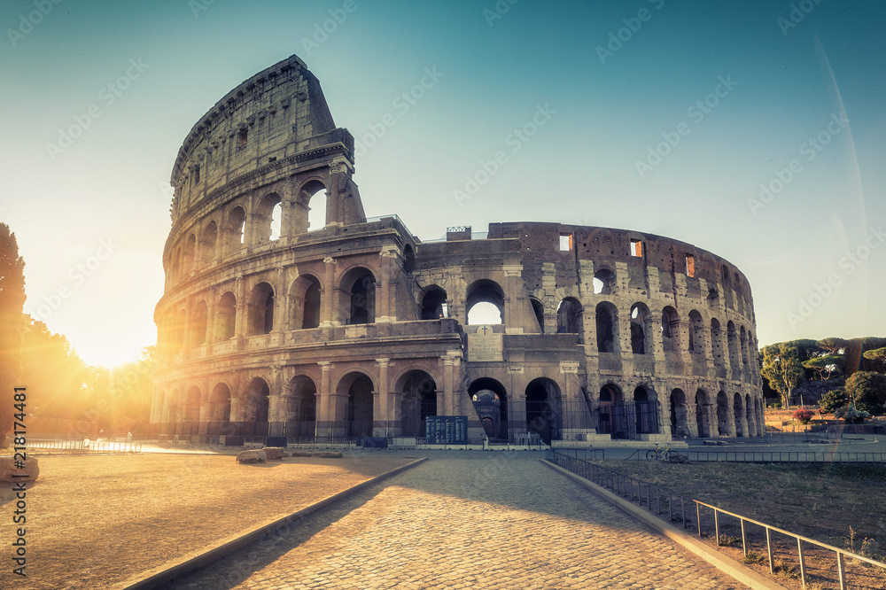 Naklejka premium Koloseum w Rzymie, Włochy o wschodzie słońca. Kolorowe tło podróży.