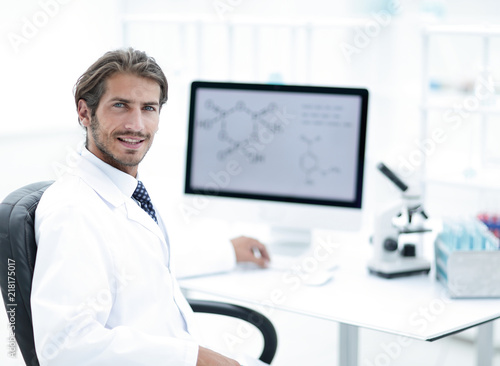 Male scientist sitting at table in laboratory