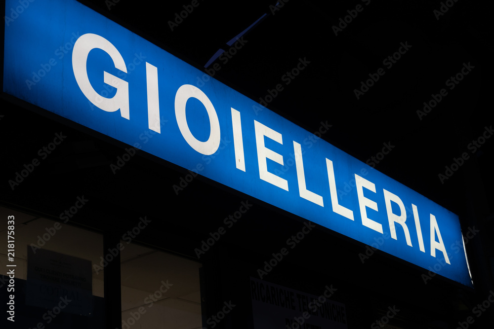 Blue signage of a gioielleria, Italian for Jewellery store, on a black background