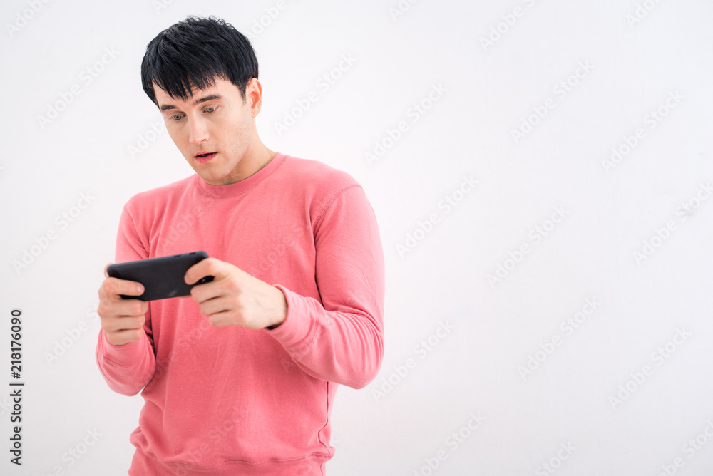 Handsome man using smart phone with white wall background Handsome man using smart phone with white wall background