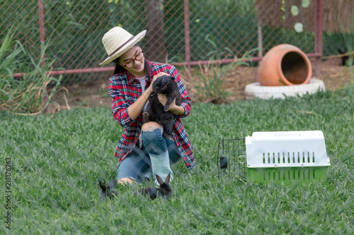 Young woman cheerful with a rabbit in rabbits farm