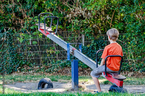 Valokuva Boy alone playing at the see-saw in the playground