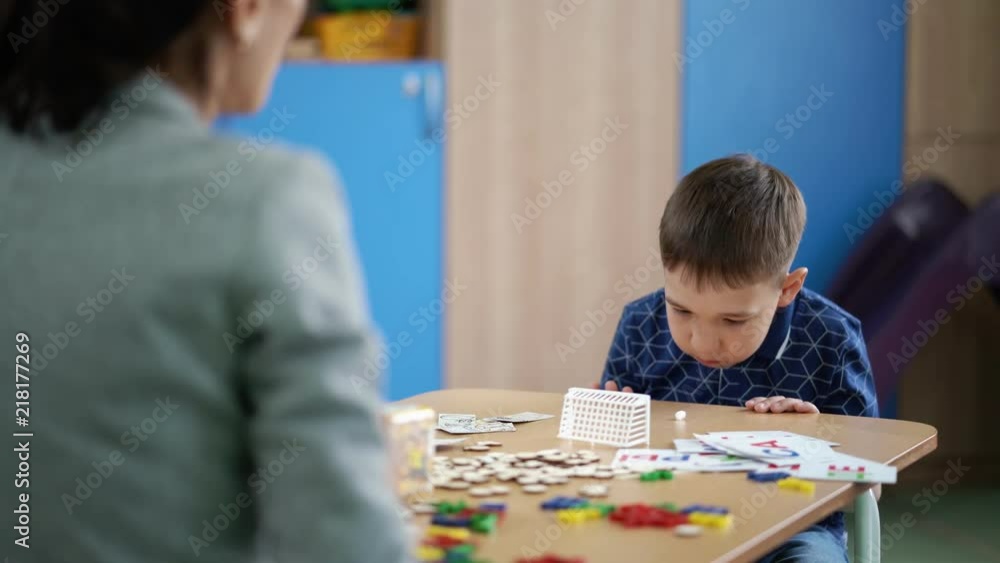 The cute boy is doing the breathing exercise at speech therapy session The cute boy is doing the breathing exercise at speech therapy session