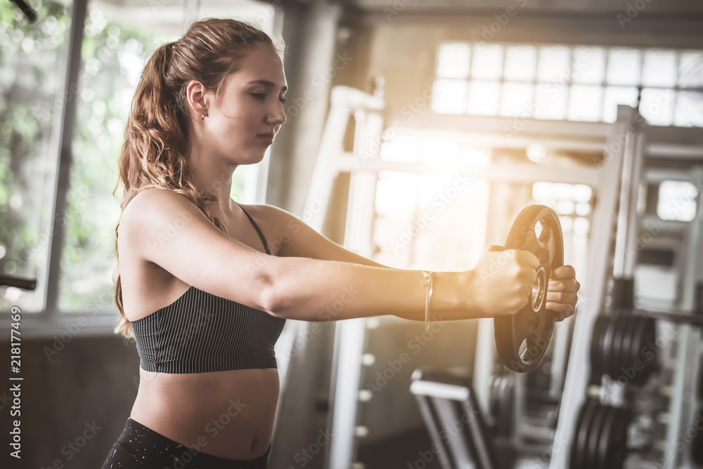 Cinematic tone of young attractive fitness woman exercise with machine in gym. Cinematic tone of young attractive fitness woman exercise with machine in gym.