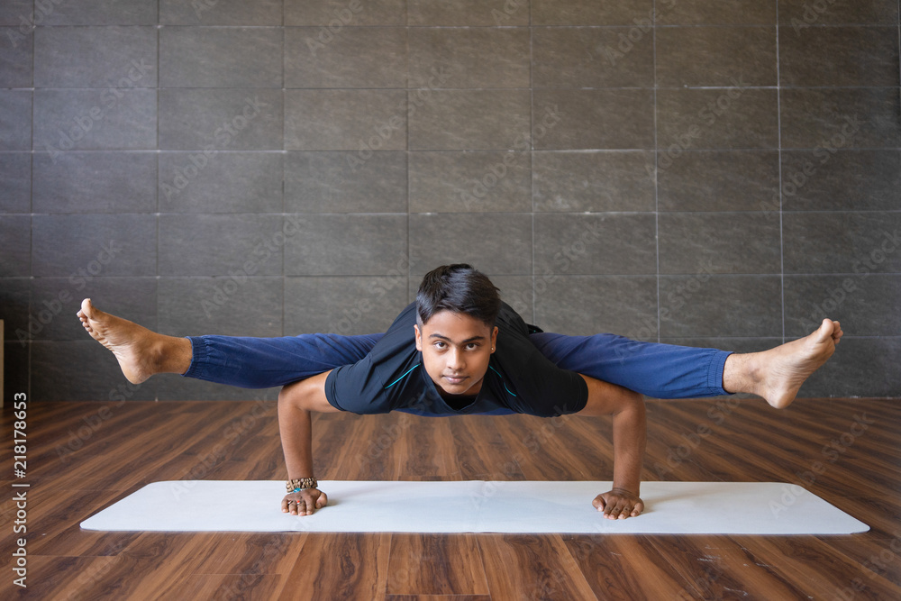 Foto Stock Young yogi doing firefly pose and balancing in gym. Man  practicing yoga and looking at camera. Yogi concept. Front view. | Adobe  Stock
