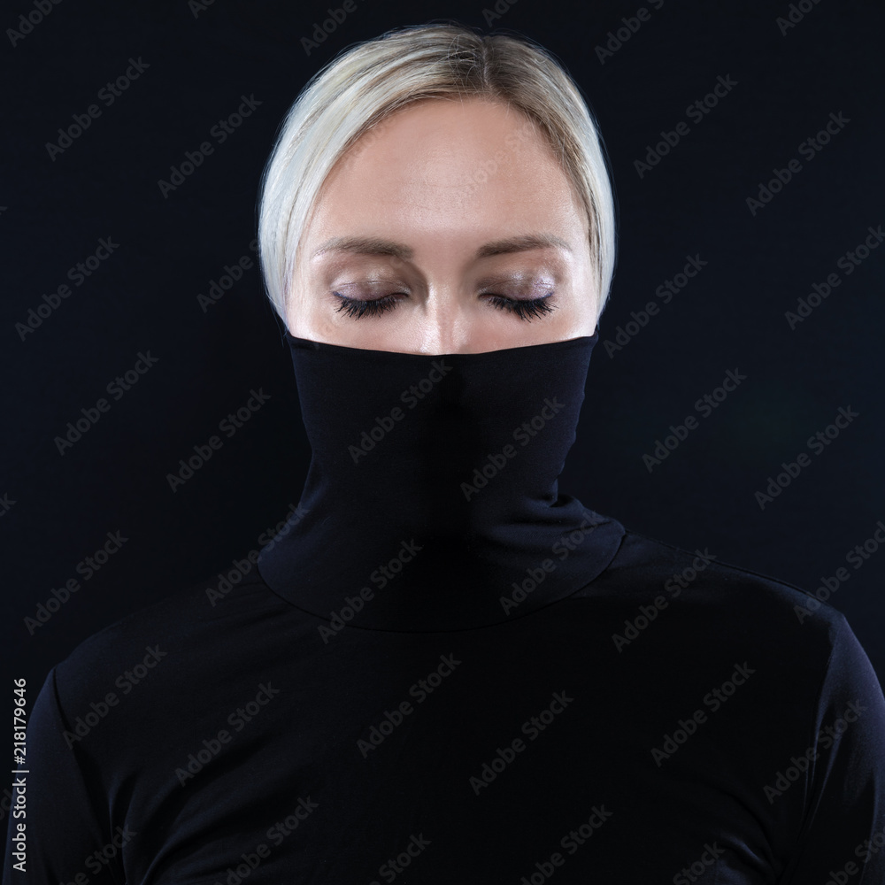 Studio portrait of beautiful elegant woman hiding face in black turtleneck Studio portrait of beautiful elegant woman hiding face in black turtleneck