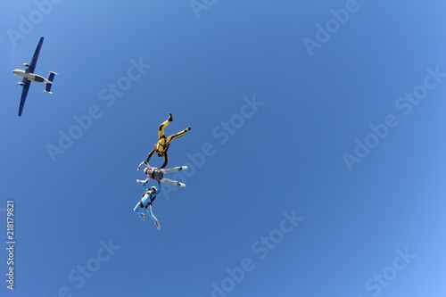 Skydiving. Two instructors are training a student to fly.