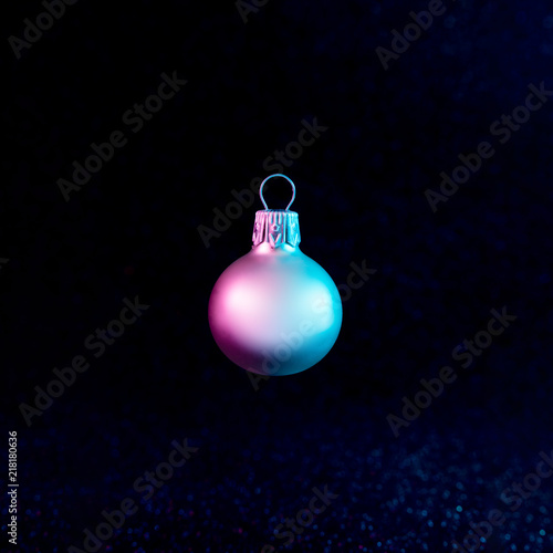 Christmas bauble decoration in vivid neon colors. Christmas dark background concept.