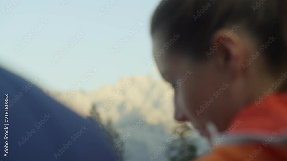 female climber pointing to a mountain summit