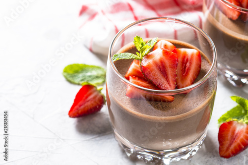 Chocolate dessert of whipped cream and strawberries in glass. photo
