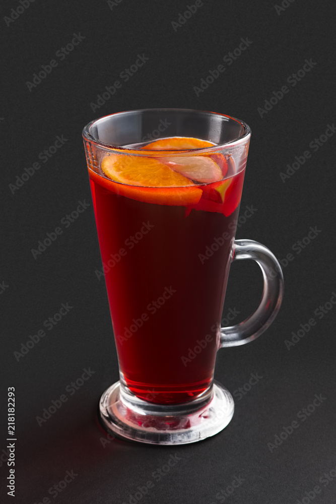 Hot cherry tea with orange and lemon on gray background Hot cherry tea with orange and lemon on gray background