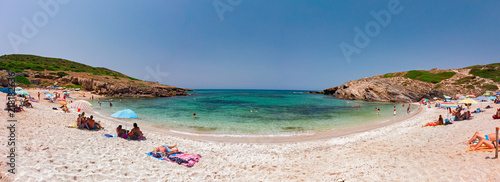 Fotografie Panoramic view of the beach of Porto Palmas in Sardinia, Italy, with some sunb