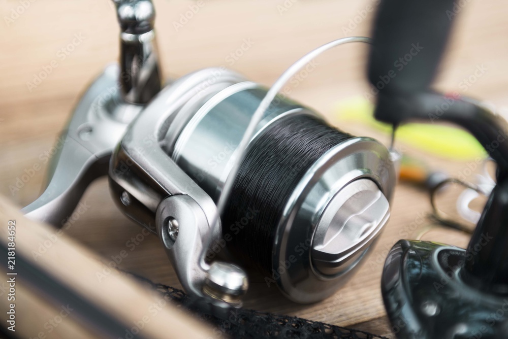 Silver fishing reel with black line. feeder fishing rod. fishing reel  isolated on table. fishing background Stock Photo
