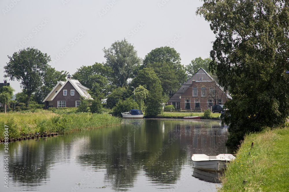 Canal with buildings and small boat, Friesland, Netherlands