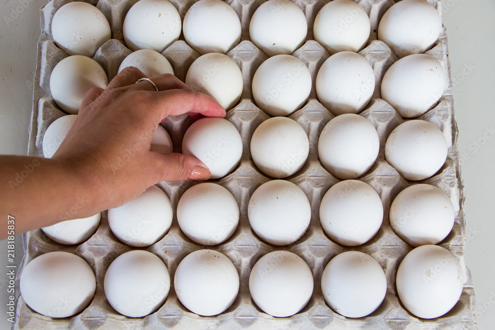 The fresh eggs in the hand. Fresh eggs on the eggs tray The fresh eggs in the hand. Fresh eggs on the eggs tray