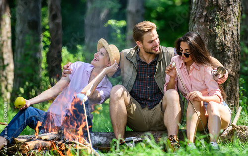 Company friends relaxing and having snack picnic nature background. Company hikers relaxing at picnic forest background. Camping and hiking. Halt for snack during hiking. Relax in nature environment