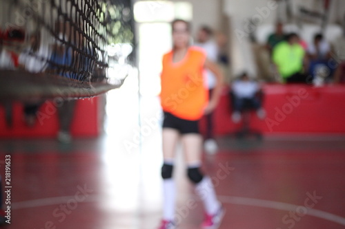 volleyball net on the gym. the girl with a ball in focus