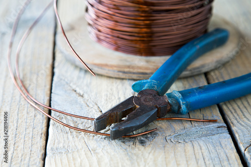 coil of copper wire and pliers close-up