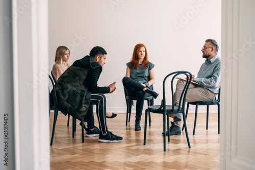 Psychotherapist talking with rebellious teenagers with alcohol addiction photo