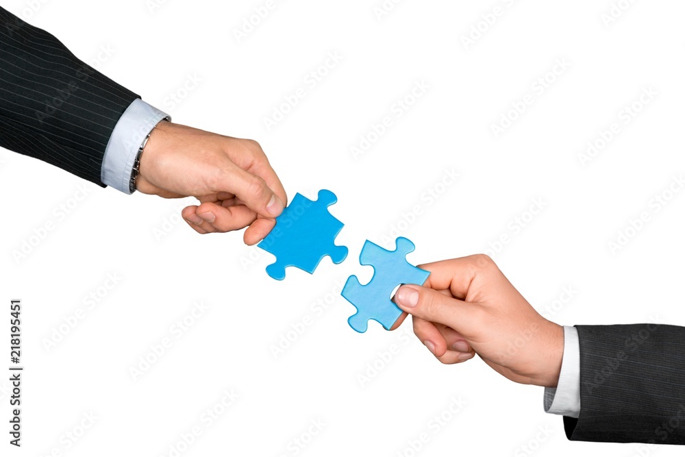 Closeup on Businesspeople Combining Puzzle Pieces Together Closeup on Businesspeople Combining Puzzle Pieces Together