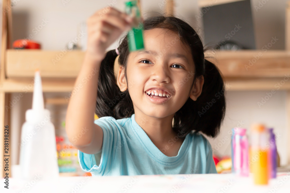 The little girl is testing color in glass and looking The little girl is testing color in glass and looking