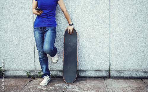 one skateboarder use mobile phone on city