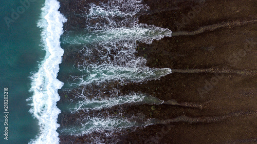 Aerial above ocean waves on a sandy beach surface photo